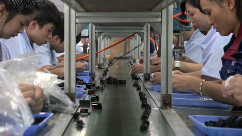 SHENZHEN, CHINA - 16 NOVEMBER 2015: Employees of an electronics factory work on the conveyor belt in Shenzhen, China