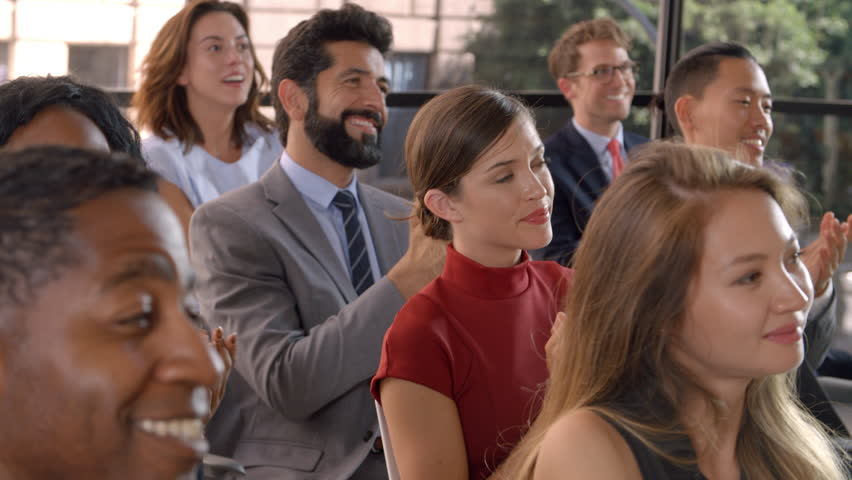 Audience applauding at a business seminar, close up