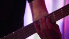 Closeup of male hands playing electric guitar solo on the concert stage. The performance of the musician.