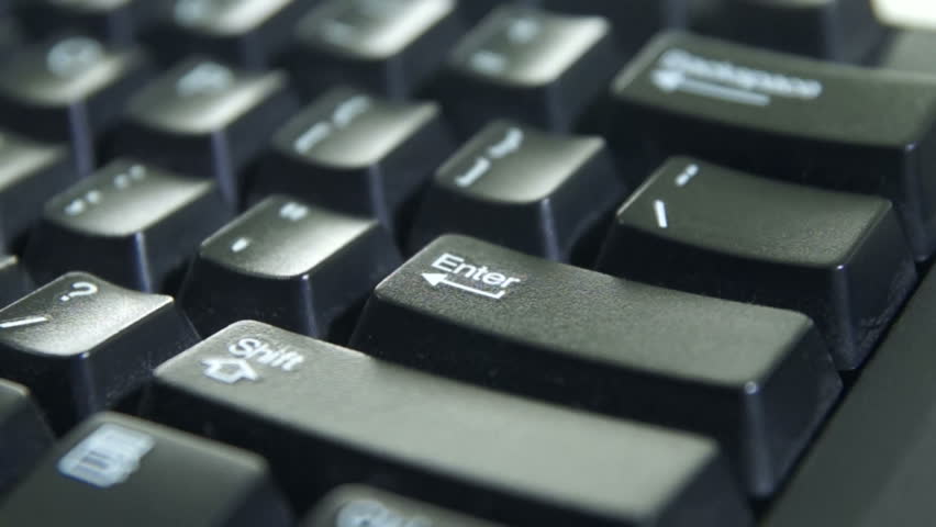 Finger typing the Enter key on a keyboard.