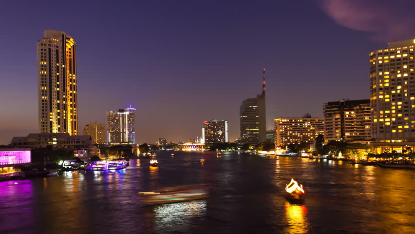 Timelapse - Bangkok city at sunset with lighted boats on the river