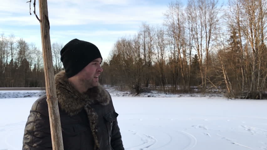 man with a dry stick in his hands in the winter in slow motion