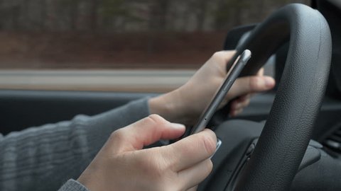 Texting on smart phone while driving on highway.