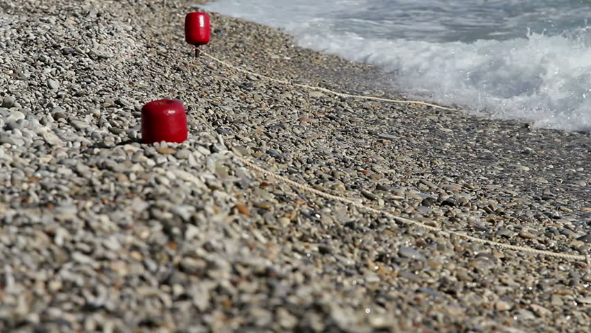 movement along the stone beach, buoys on the beach
