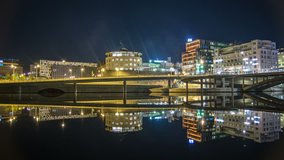 Time Lapse of office buildings and bridge at night. Reflections in the canal, Stockholm, Sweden