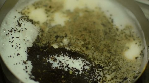 Beautiful close up stock footage of tea making, boiling steam generating from hot water and milk. It is a favourite drink called "chai" for Bengalis of Kolkata, Calcuatta, West Bengal, India .