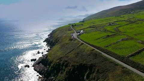 The view of the sea fronting the town of Dingle with a long road on the side of the island in Ireland