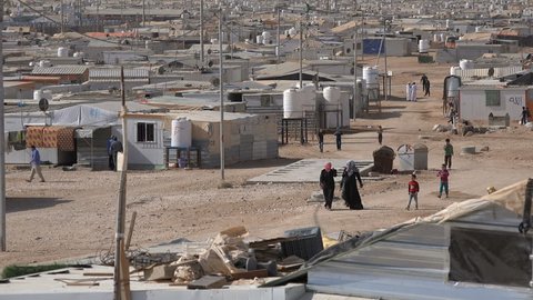 ZAATARI REFUGEE CAMP, JORDAN - 18 NOVEMBER 2016: Syrian refugees walk through makeshift homes in the Zaatari camp in Jordan