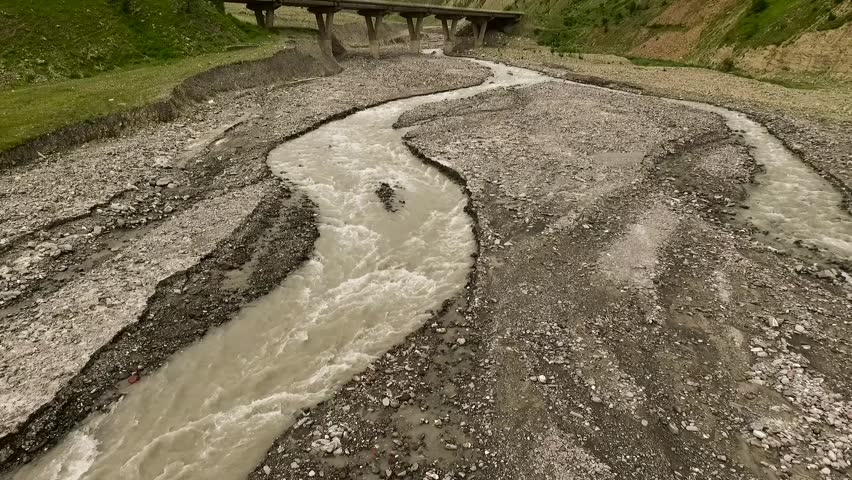AERIAL: mountain river with a bridge on which the truck travels