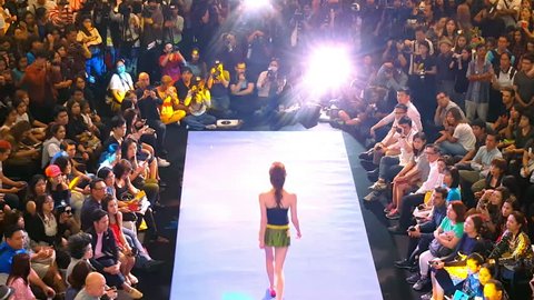 BANGKOK, THAILAND - 3 MAR 2016: attractive female model walks runway demonstrating beachwear to public and photographers at fashion show in shopping mall Siam Paragon. Back view. Footage with audio.