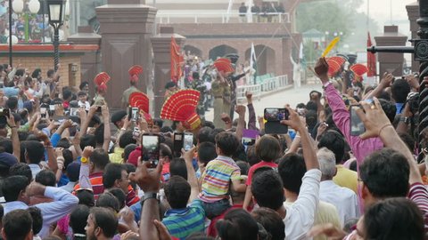 AMRITSAR, INDIA - OCTOBER 2014: People take photos with their smartphones of the classic India Pakistan border ceremony in Amritsar
