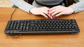 Business girl with a nice manicure typing on black keyboard