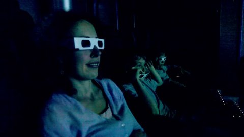 Family in 3d stereo glasses sit at cinema and watch movie with chair shake effects for motion imitation