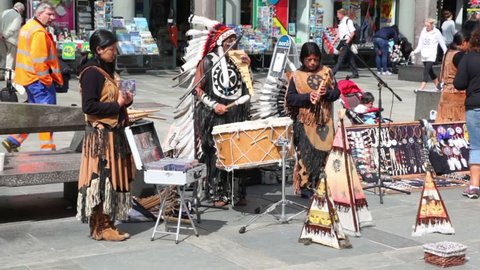 BERGEN - JUNE 27: Few native Americans in national costumes play music on street, people walk around on JUNE 27, 2011 in Bergen, Norway.