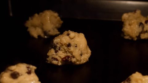 Homemade chocolate chip and raisins cookies - time lapse video. Raw dough melting in oven and changing color to golden brown