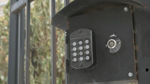 Person pushing the buttons on the panel of the intercom outdoors