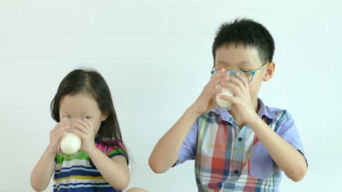 Little brother and sister drinking milk together