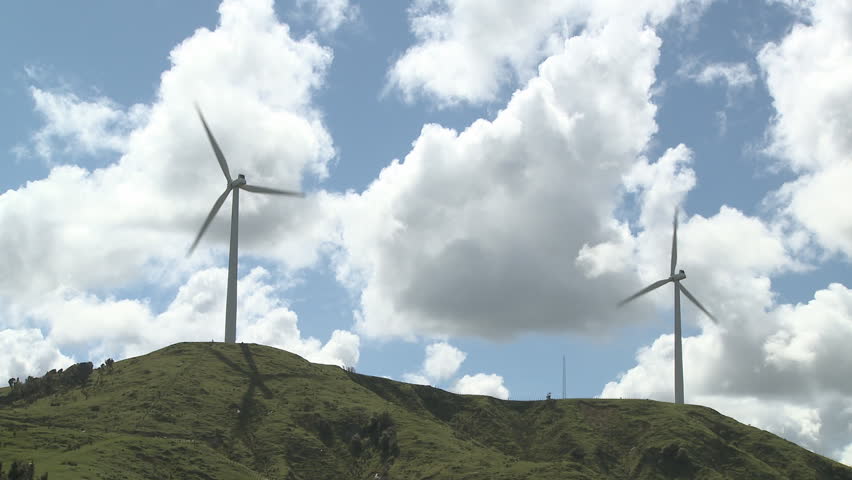 Wind turbines on top of a hill producing electricity