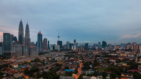 Time lapse: Dramatic and cloudy sunset view of the Kuala Lumpur skyline overlooking the national landmarks, the Petronas Towers and Kuala Lumpur Tower