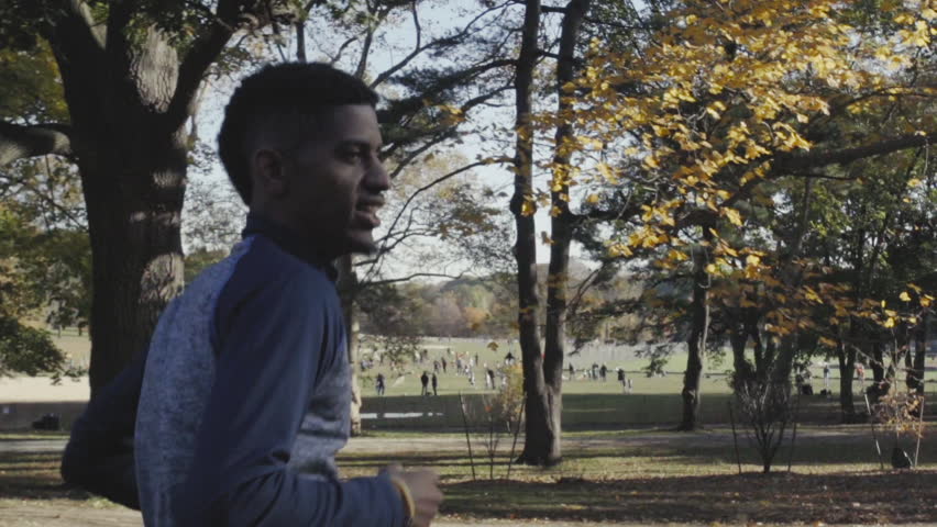 A shot of a young, black man running through Prospect Park in Brooklyn, NYC.