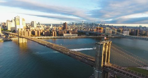 An aerial shot of New York City's Brooklyn Bridge at sunrise. The bridge connects the boroughs of Brooklyn and Manhattan while spanning The East River. 