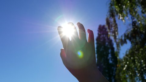 Motion of raised hand in the sky against the sun with 4k resolution