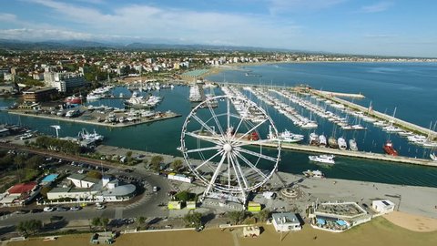 A beautiful Bay to Rimini with a floating yacht and Ferris wheel, aerial view