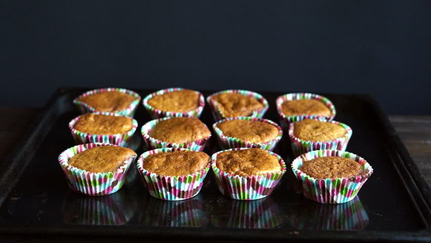 Chef take away cupcake from baking tray. Cooked cupcakes on baking pan. Homemade bakery. Muffin cake in muffin tray. Cooking homemade cupcakes