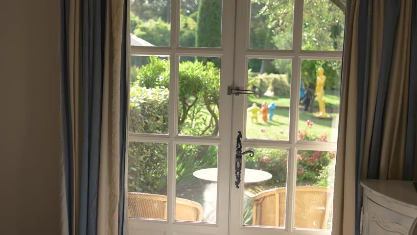 Nature behind the door. White frames with glass panels. Mansion with a garden.