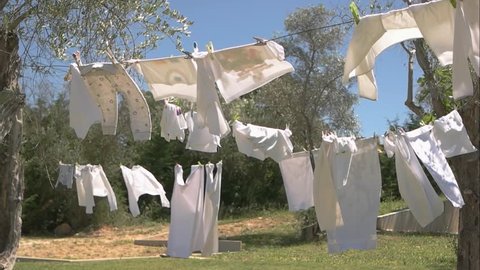 Clothes in the wind. Grass, trees and sky. New washing powder commercial.