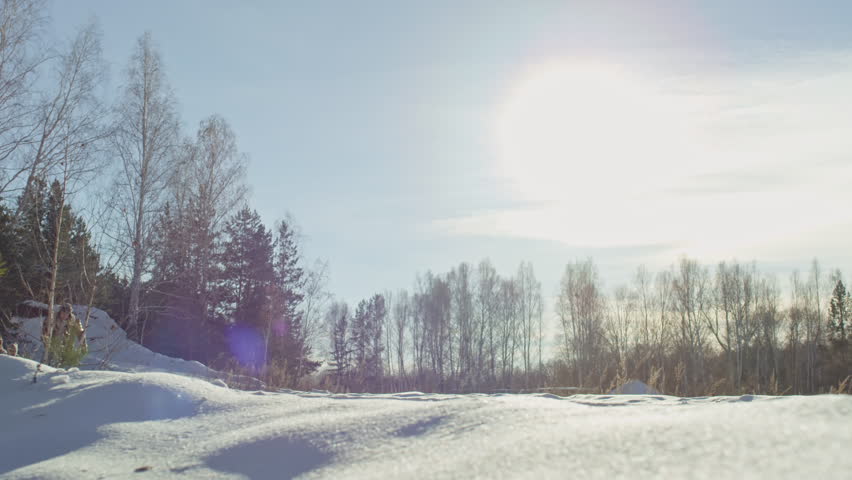 Lockdown of man pulling sled with happy woman and boy on sunny winter day