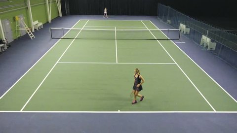 Two women tennis players in black and white dress professionally trained on the tennis court. Fifty FPS
