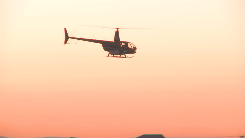A helicopter set against a sunrise sky