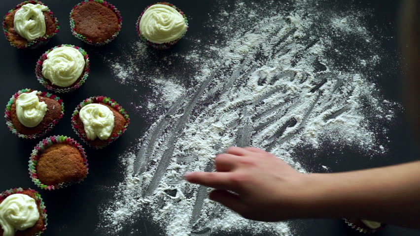 Happy birthday writing on white flour spills. Finger writing. Inscription happy b-day on white flour on kitchen table. Happy birthday celebration