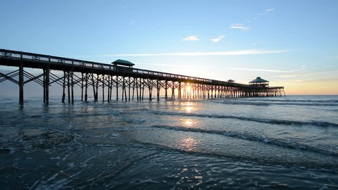The pier at Folly Beach and waves in the Atlantic Ocean at sunrise, near Charleston, South Carolina.