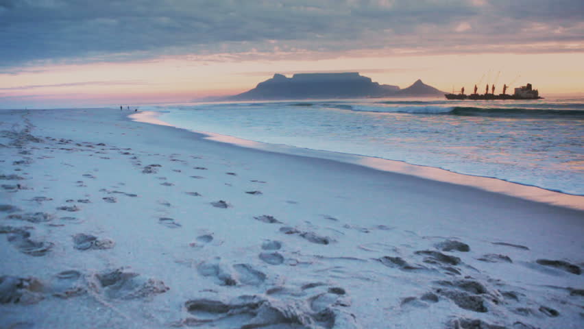 Looking down West Beach in Cape Town, South Africa at dusk, with Table Mountain in the background.