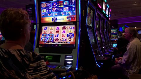 Coquitlam, BC, Canada - September 02, 2016 : Motion of people playing slot machine inside Hard Rock Casino with 4k resolution