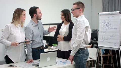 Positive office people laughing at a joke told by male coworker