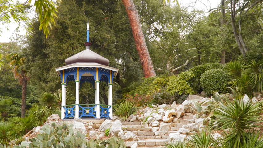 Wooden gazebo in the park among the trees.