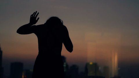 Silhouette of sad, desperate woman crying by window at night at home, super slow motion 120fps
