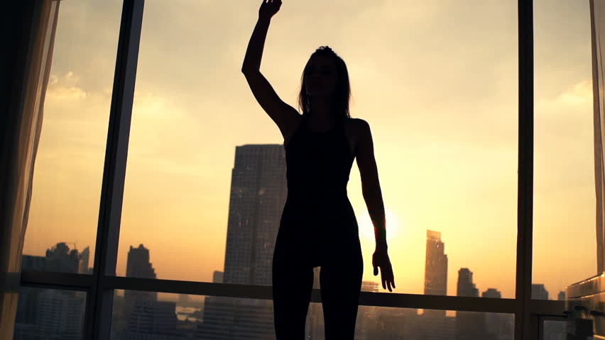 Silhouette of woman exercising, stretching arms by window at home, super slow motion 240fps
 | Shutterstock HD Video #23283940