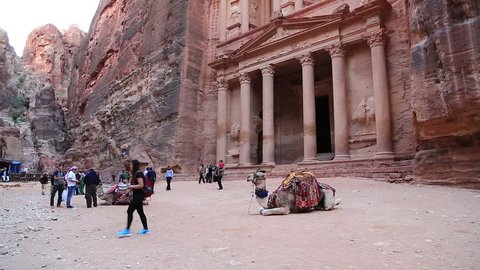JORDAN, PETRA, DECEMBER 5, 2016: People and camels near Al Khazneh or the Treasury at Petra, originally known to Nabataeans as Raqmu - historical and archaeological city in Hashemite Kingdom of Jordan
