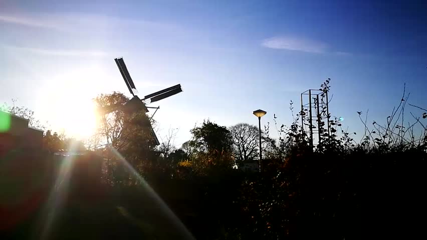 Rotating windmill in the sunshine in slow motion. Sun backlight illumination in Nijmegen, Netherlands
