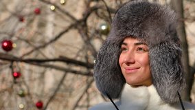 Young woman in gray fur head cloth outdoor in winter wind