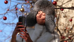Salfie. Young woman in gray fur head cloth outdoor in winter 