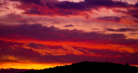 Red sunset sky timelapse, beautiful orange sun light, nature landscape over mountains, fast motion of dramatic clouds in bright evening colors, yellow dusk sunlight, beauty of summer background video