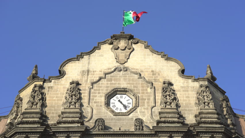 Basilica of Guadalupe clock tower with Mexican flag - December 2016. Mexico City, Mexico