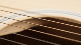 Wooden acoustic guitar E string vibration shallow DOF 4K 2160p 30fps UltraHD panning footage - Detailed plucked instrument body slow pan 3840X2160 UHD video