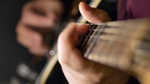 A man plays the guitar. Close-up