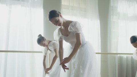 Three Young and Gorgeous Ballerinas Synchronously Dancing. They Wear White Tutu Dresses. Shot on a Sunny Morning.In Slow Motion.Shot on RED EPIC-W 8K Helium Cinema Camera.